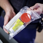 22 June 2022, Hamburg: An officer of the Federal Police shows at Hamburg Airport during the security check which quantities of liquids may be carried and how they must be packed. (to dpa "Busy at the airport - this is how the security check works") P